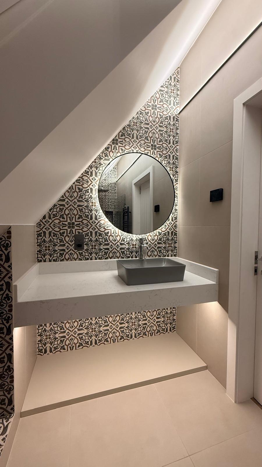 Finished cloakroom in the Totteridge conversion with patterned tiles, floating vanity and illuminated round mirror