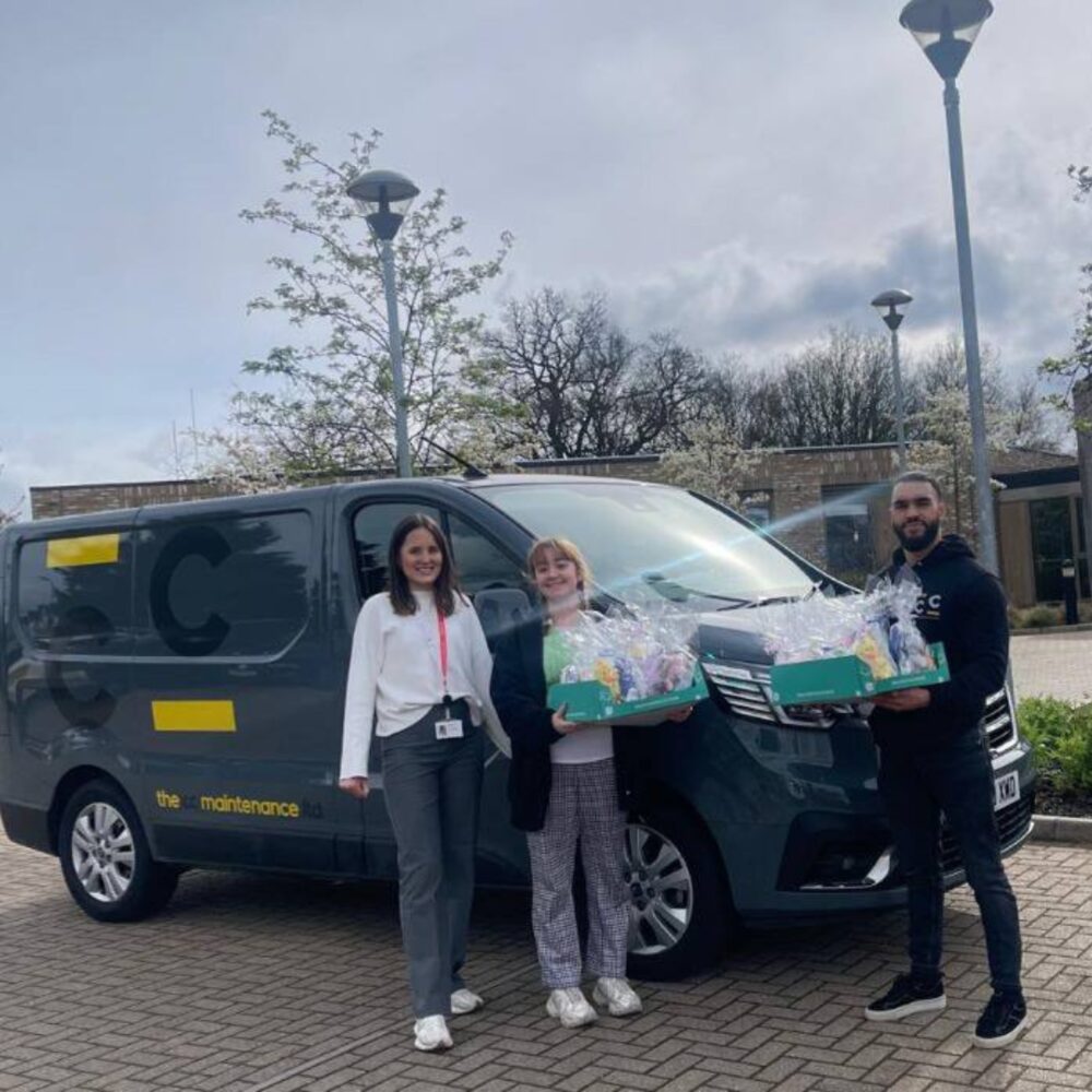Construction Collective team delivering Easter hampers beside a company van at the hospice