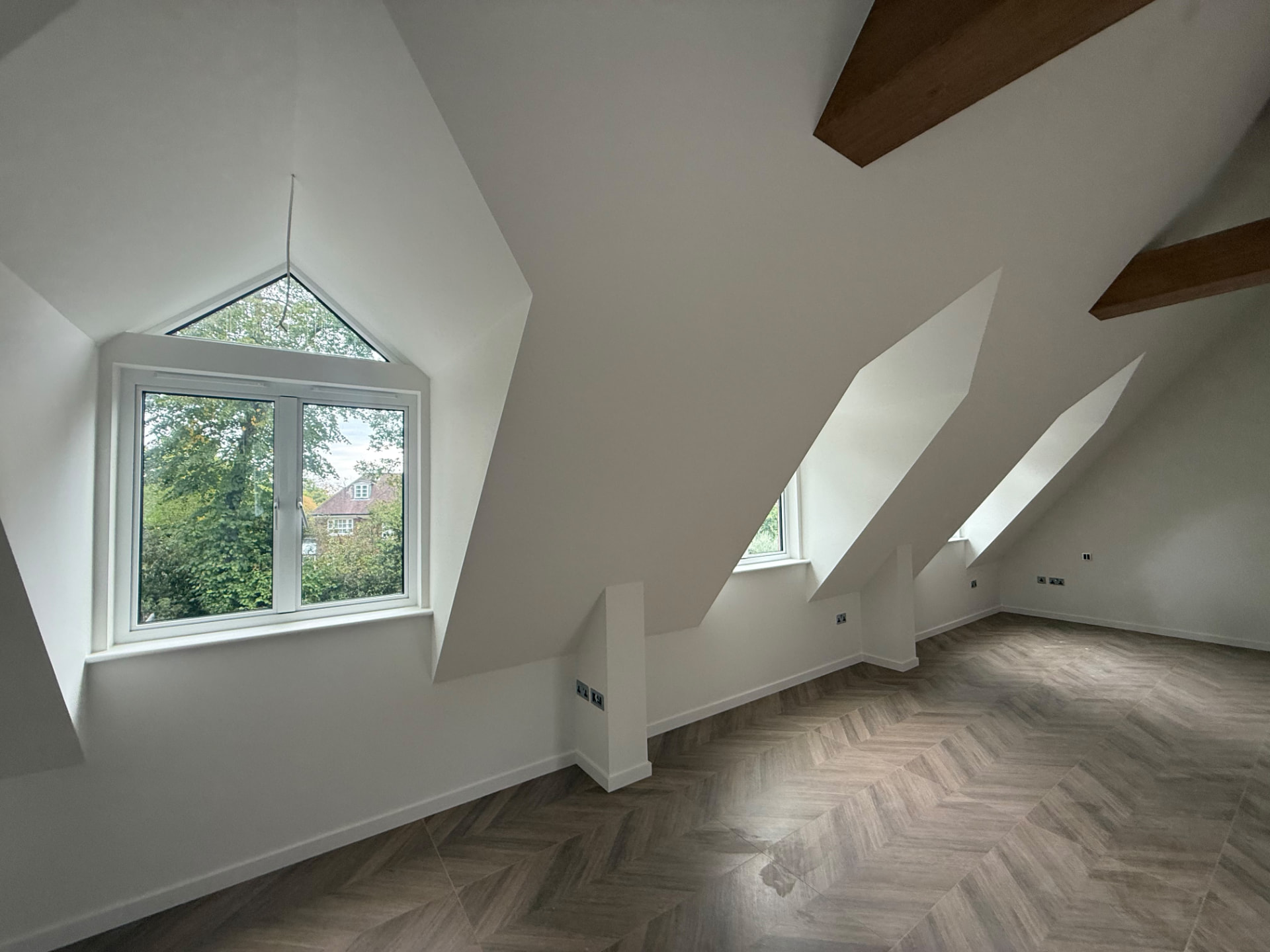 Bespoke garage conversion in Totteridge North London - The Construction Collective - vaulted living area with gable window and dormer reveals