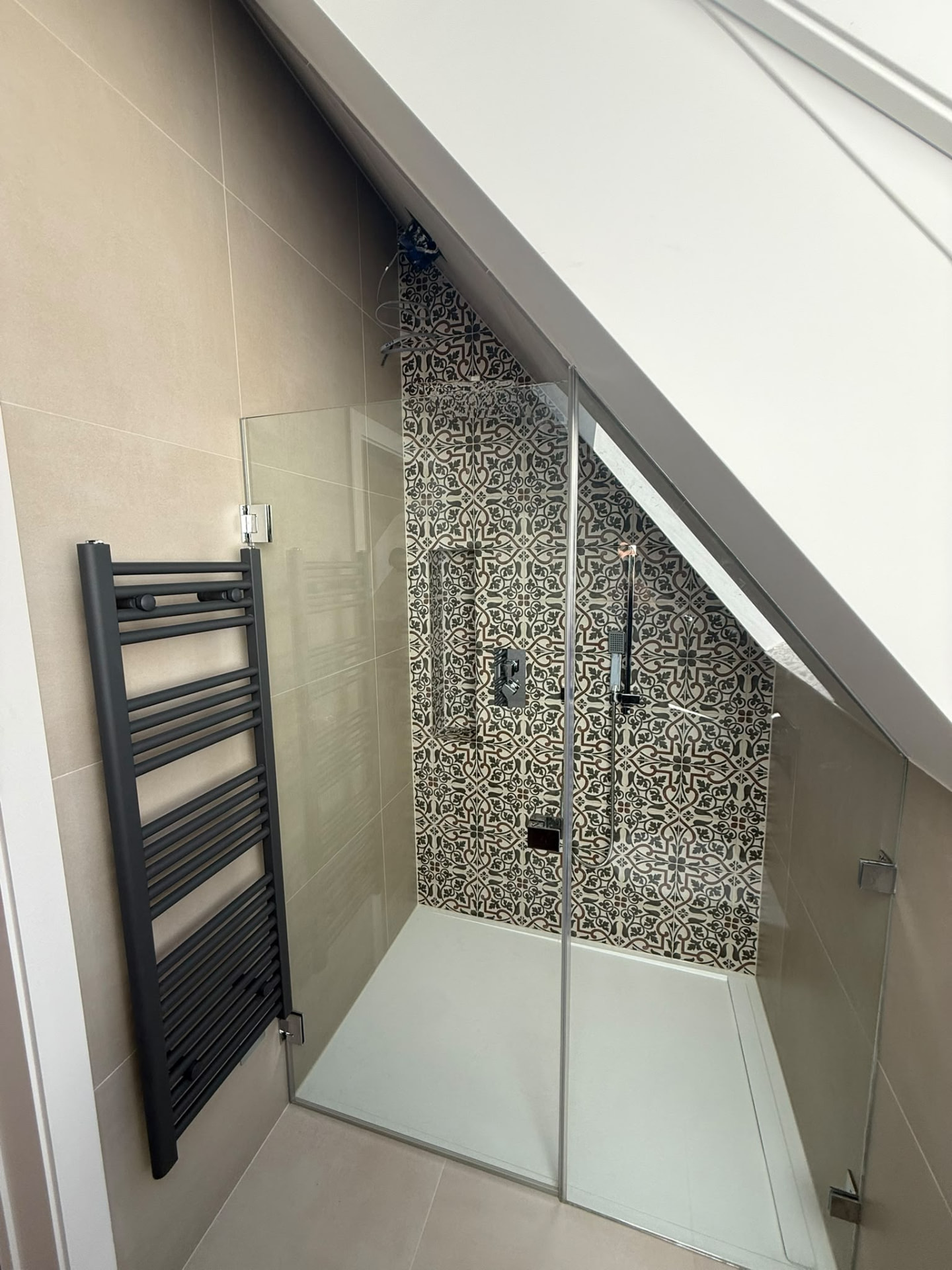 Bespoke garage conversion in Totteridge North London - The Construction Collective - walk-in shower with patterned feature tiling under the eaves