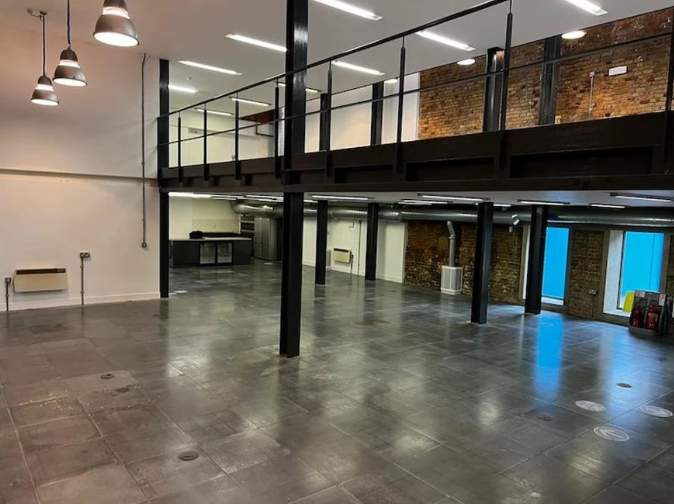 Open-plan commercial floorplate with steel mezzanine, exposed brick and LED lighting ready for Cat B fit-out